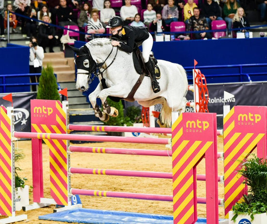 Jennifer Jaritz and her horse jumping over obstacle at show jumping tournament